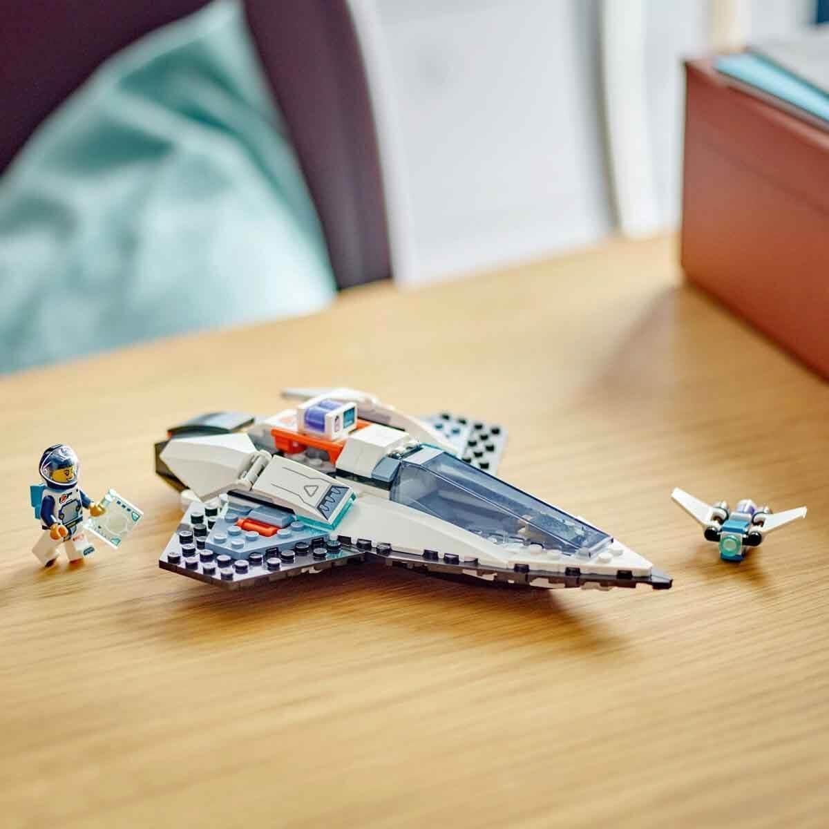 LEGO spaceship toy set with astronaut minifigure and small drone on wooden table