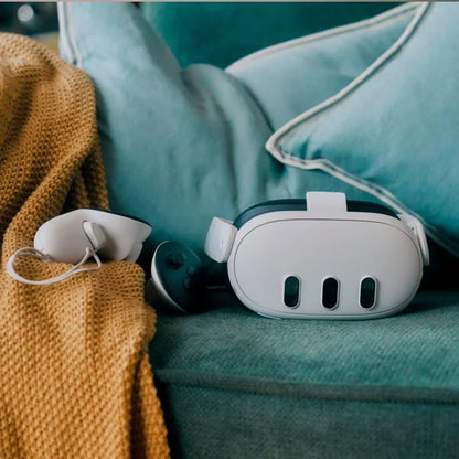 Virtual reality headset and controllers on teal sofa with mustard yellow blanket
