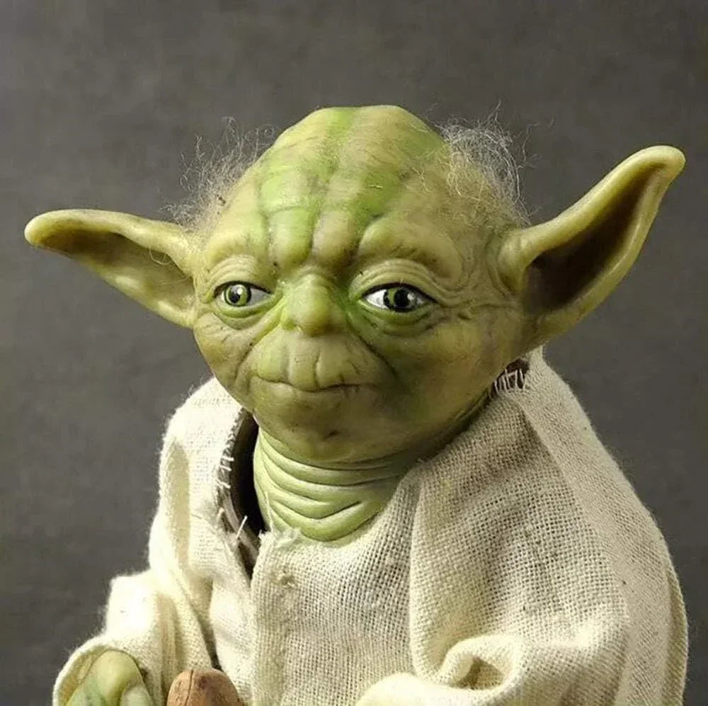 Collectible green alien action figure with large ears and white robe, detailed facial features.