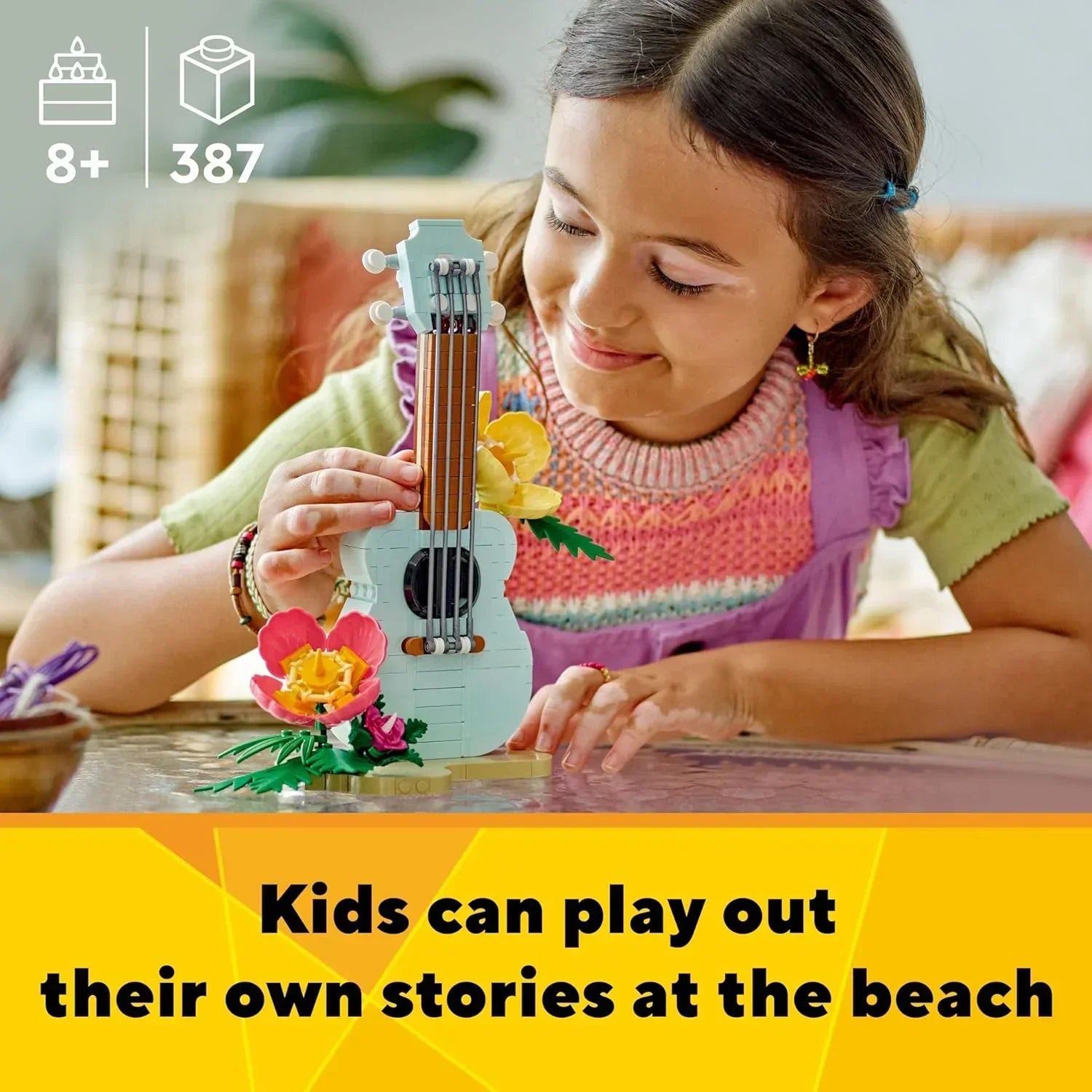 Smiling child building a LEGO guitar set with flowers, age 8+, 387 pieces, indoor play.