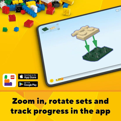 Tablet displaying LEGO building instructions app with colorful LEGO bricks scattered on yellow background.