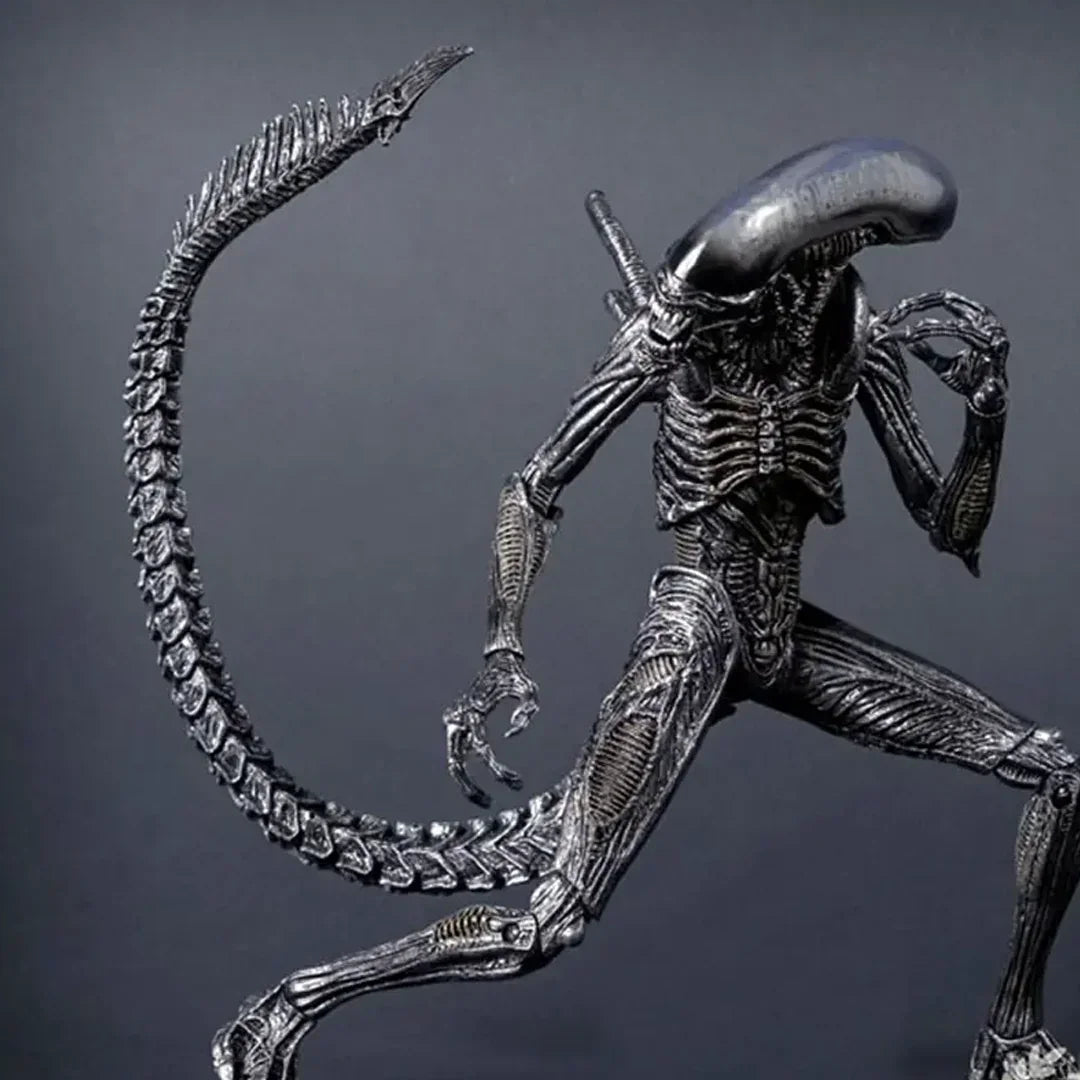 Detailed alien action figure collectible toy with long tail and biomechanical design on gray background