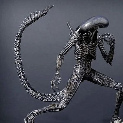 Detailed alien action figure collectible toy with long tail and biomechanical design on gray background