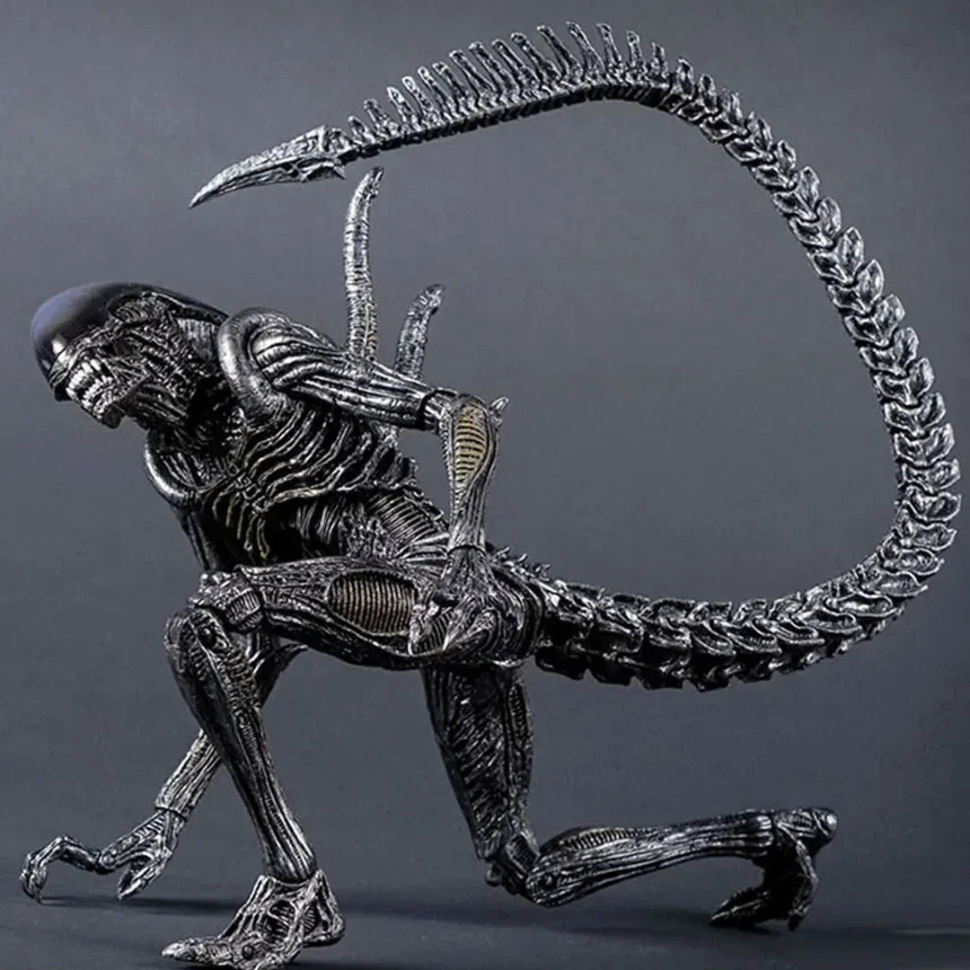 Highly detailed alien action figure with long tail and biomechanical features on display.