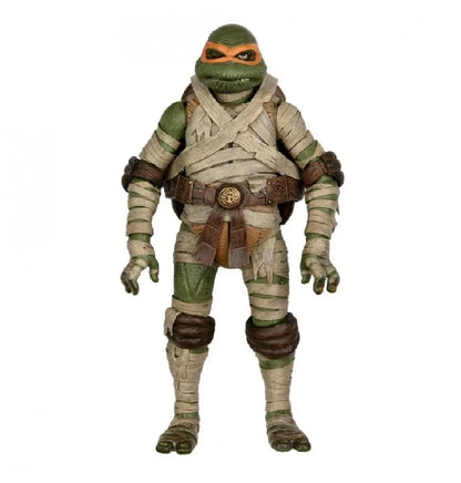 Action figure of a green ninja turtle wrapped in bandages with an orange mask and belt