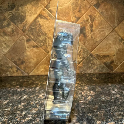 Dinosaur action figure toy in sealed plastic packaging on a granite countertop