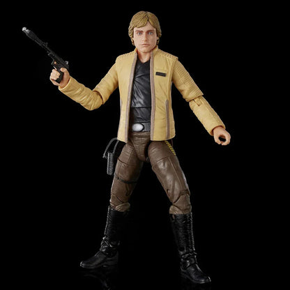 Collectible action figure in yellow jacket and brown pants holding toy blaster on black background
