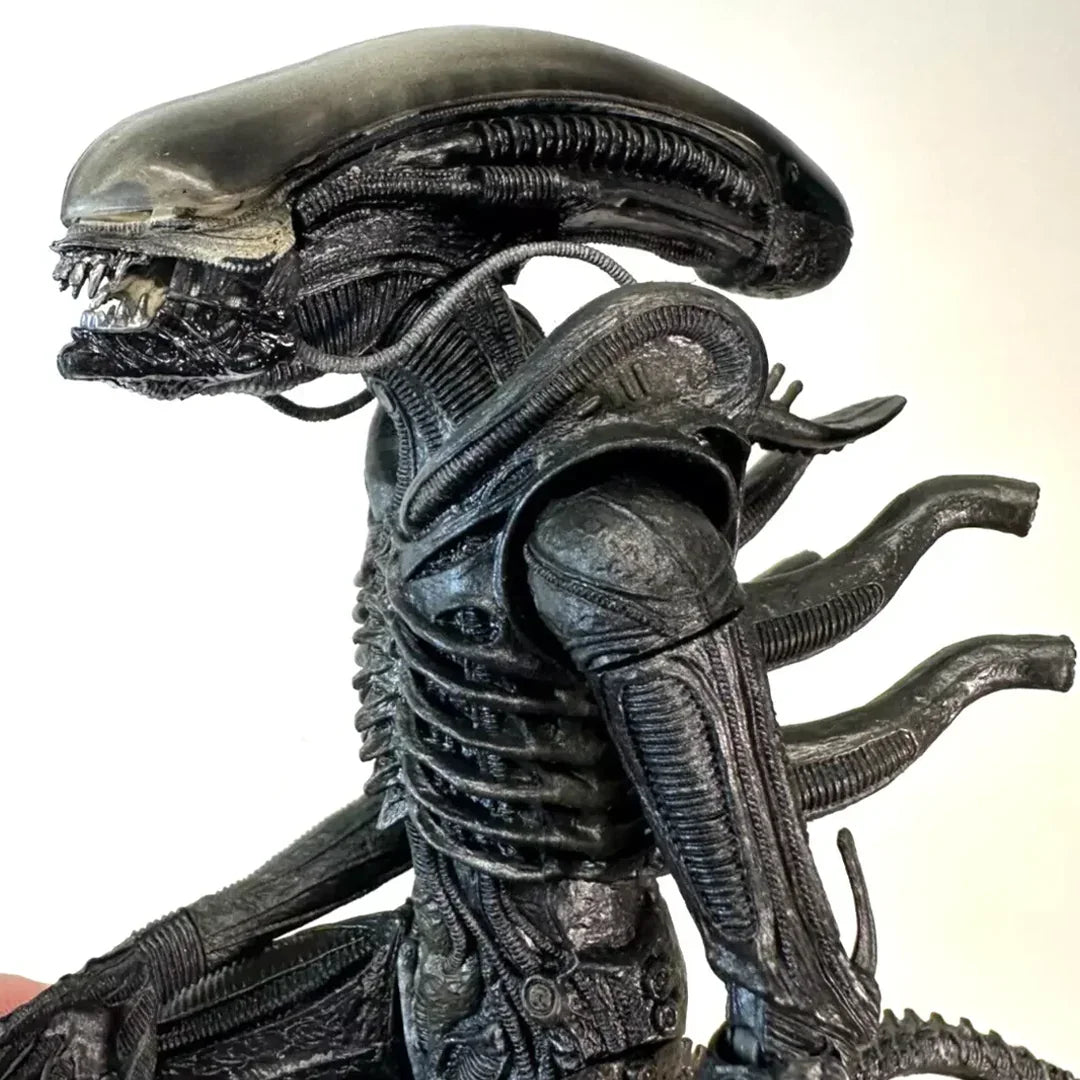Detailed black alien action figure collectible with ridged body and elongated head