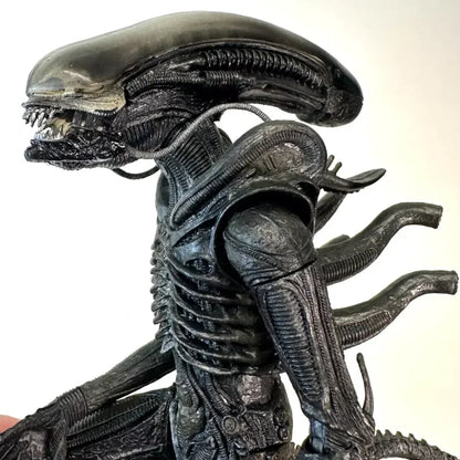 Detailed black alien action figure collectible with ridged body and elongated head