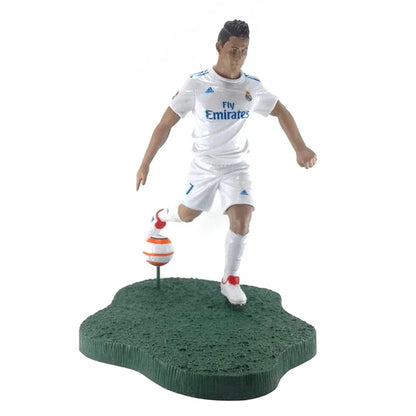Soccer player action figure in white uniform on grassy base with orange and white soccer ball