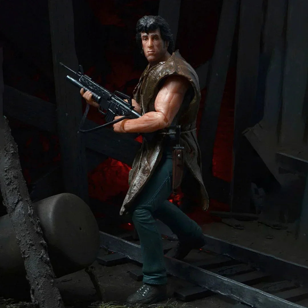 Action figure of a muscular man with rifle in a dark, rugged setting, collectible toy