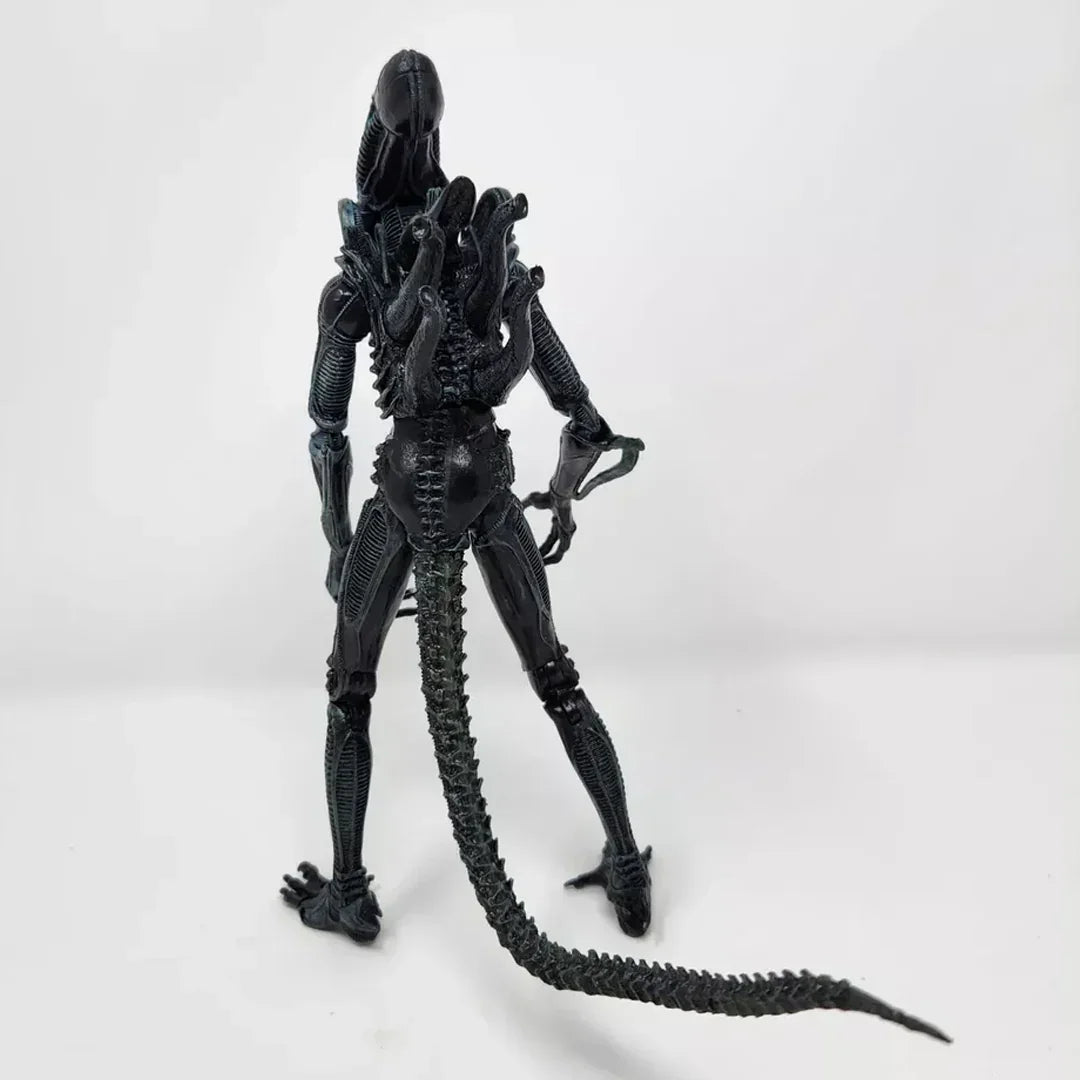 Alien action figure collectible with long tail and detailed black exoskeleton, rear view