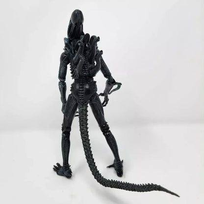Alien action figure collectible with long tail and detailed black exoskeleton, rear view