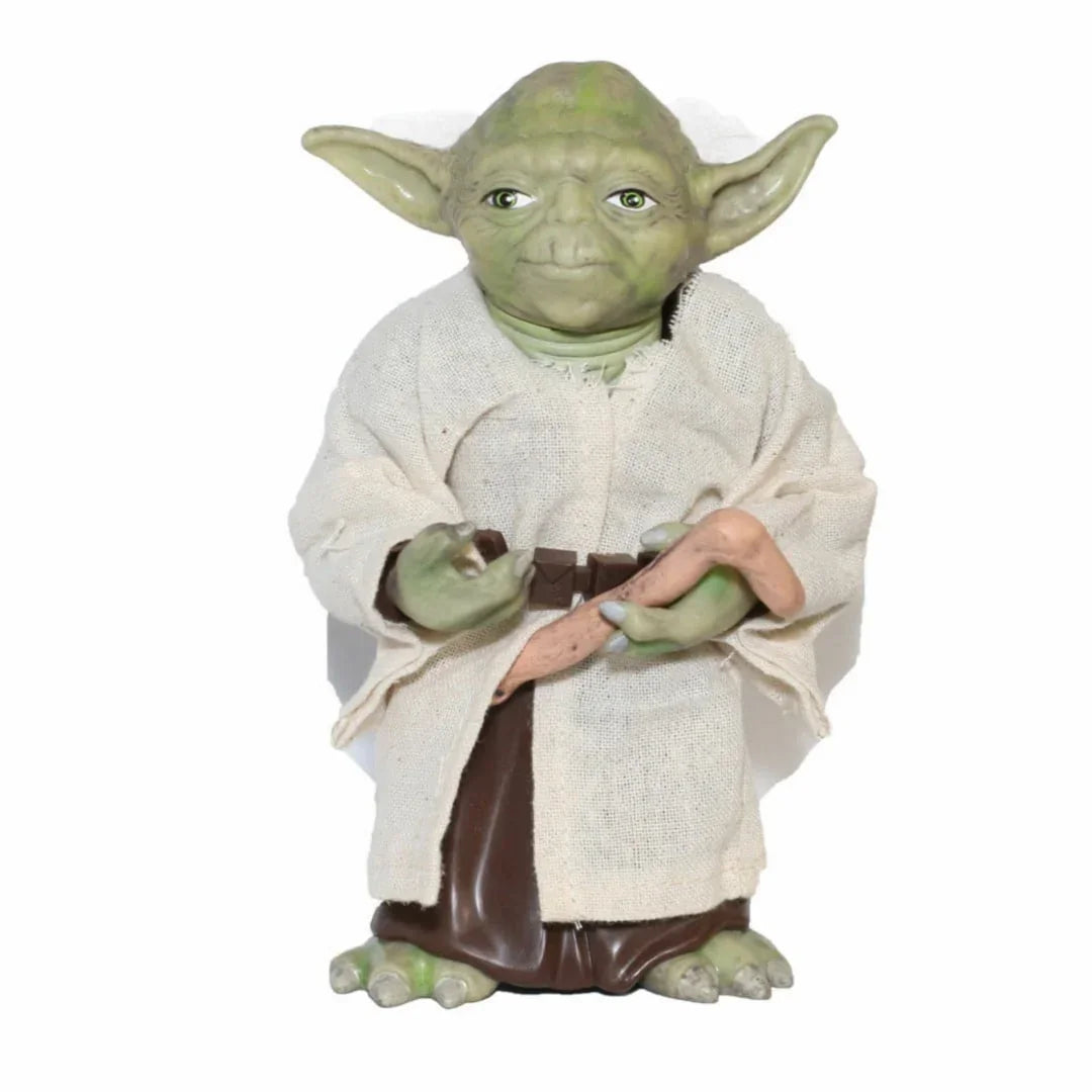 Green alien action figure in robe with cane, collectible toy on white background