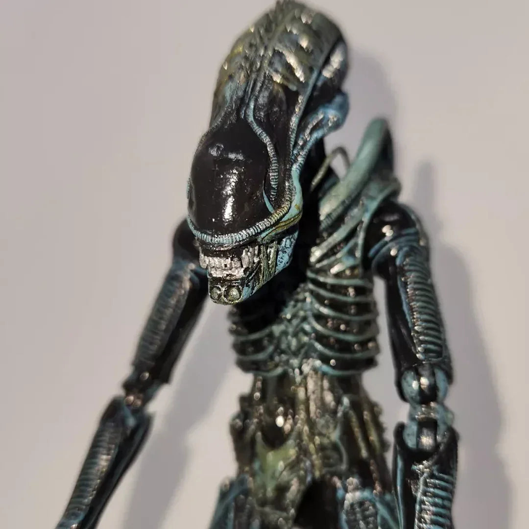 Detailed alien action figure with biomechanical design, ridged head, and skeletal body