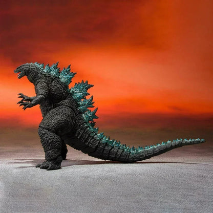 Godzilla action figure toy with textured details and blue spikes against an orange backdrop