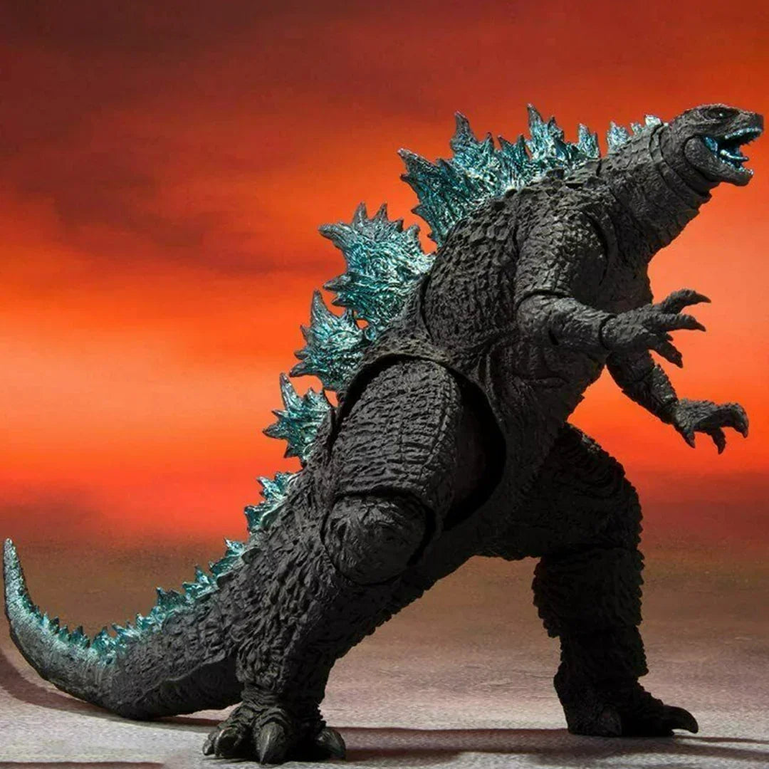 Godzilla action figure with blue spikes against a dramatic orange background, collectible toy