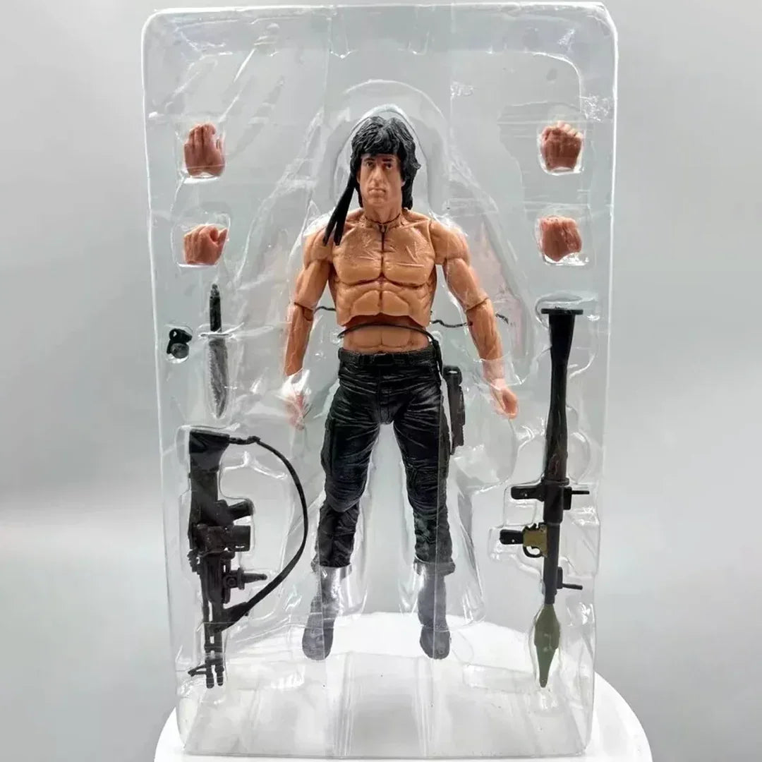 Muscular action figure with black pants, weapons, and interchangeable hands in packaging.