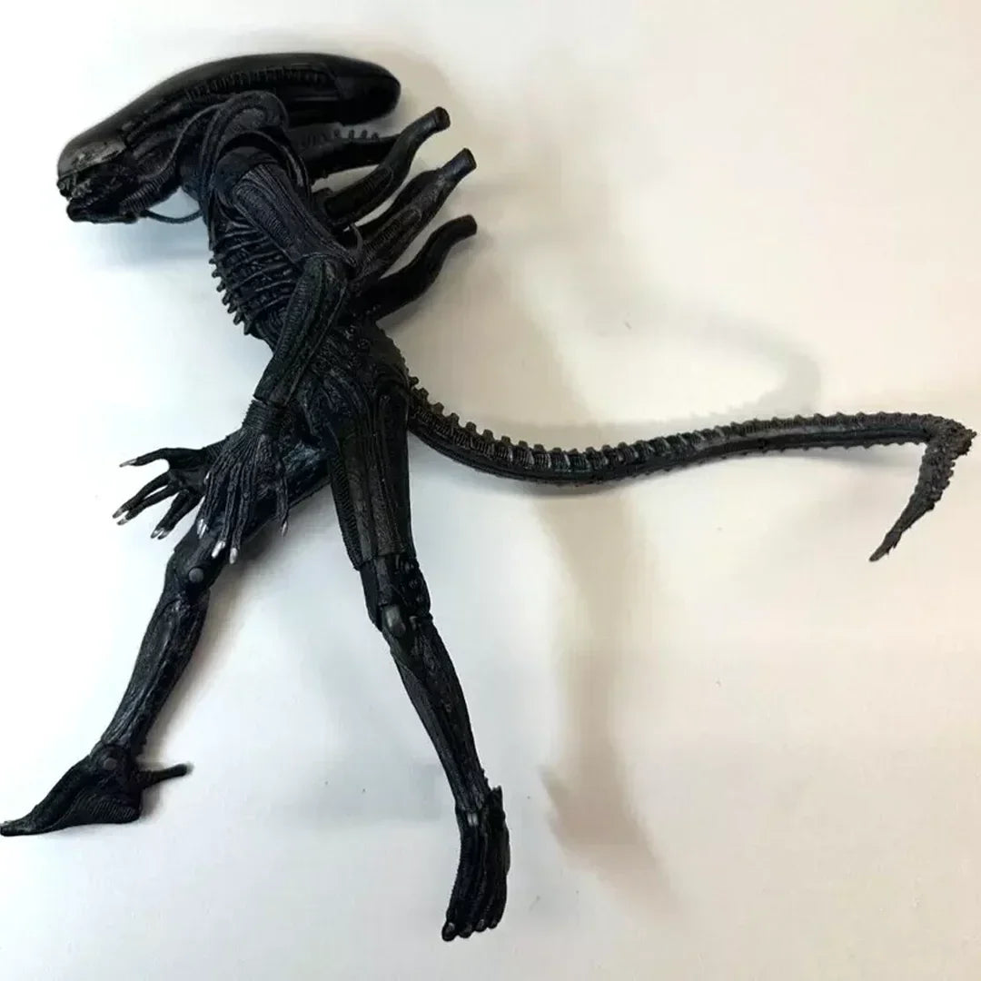 Black alien action figure collectible toy with long tail on white background