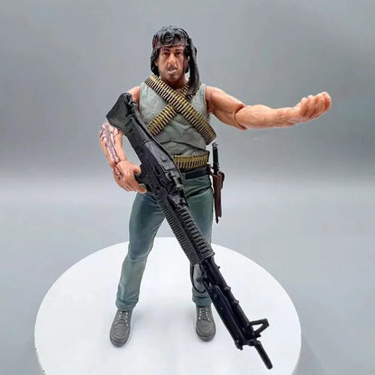 Action figure of a muscular soldier with bandolier, headband, and large rifle on display stand