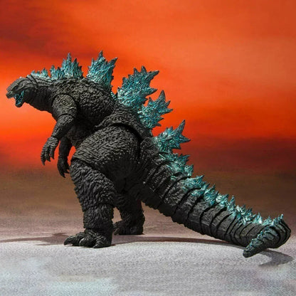 Godzilla action figure toy with blue spikes, detailed texture, against orange background