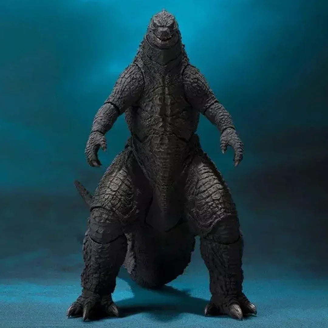 Realistic Godzilla action figure toy posed upright against a blue background.