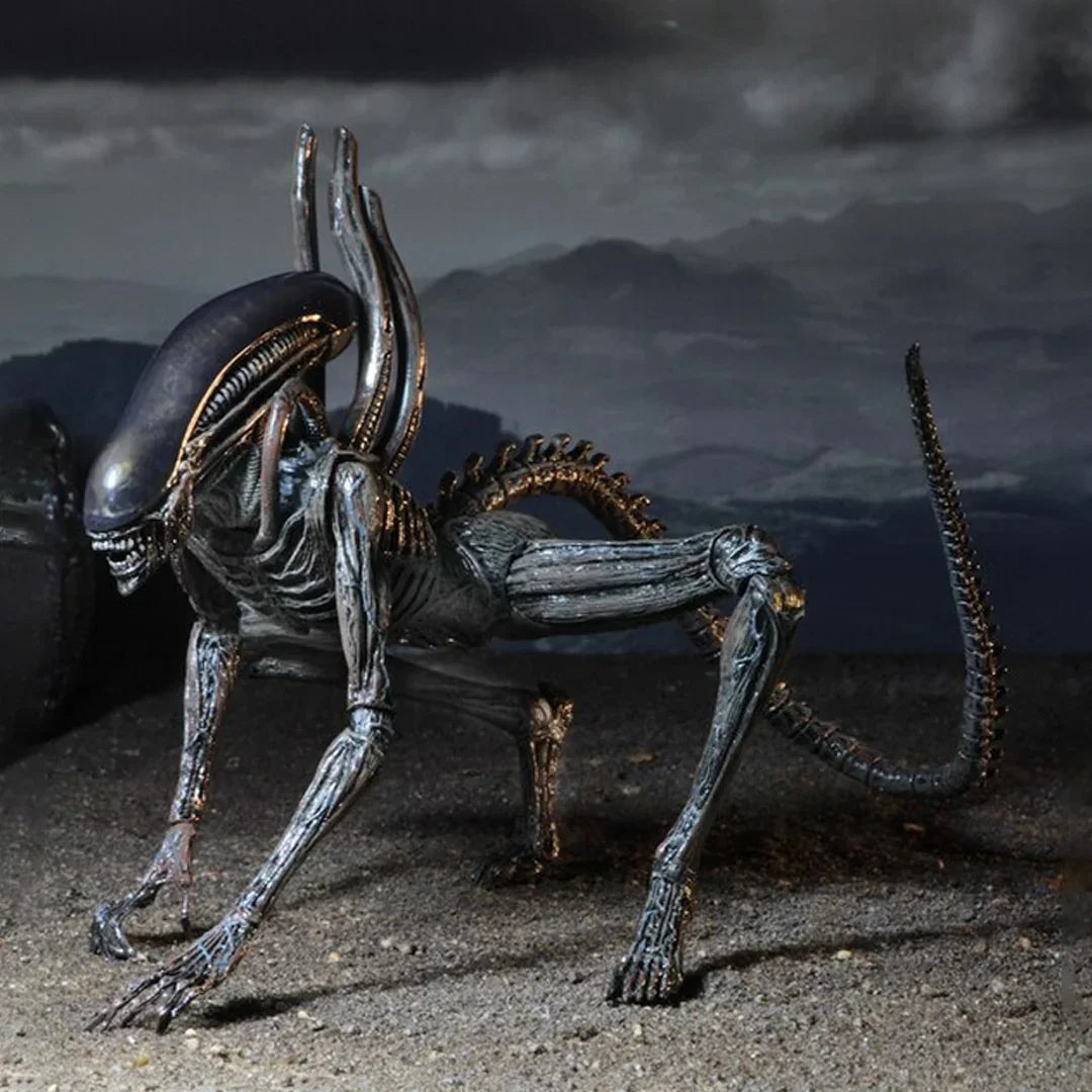 Alien action figure collectible toy with elongated head and tail on dark rocky terrain