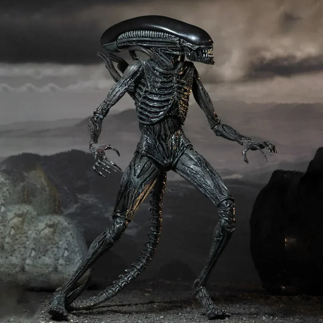 Detailed alien creature action figure with elongated head and tail on rocky background, collectible toy.