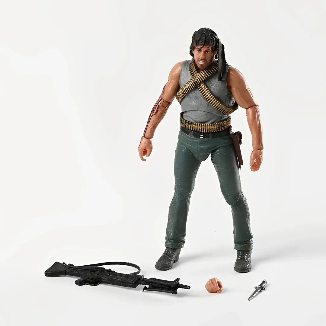 Action figure of a muscular soldier with ammo belts, rifle, knife, and spare hand accessory.