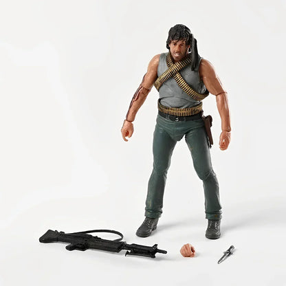 Action figure of a muscular soldier with ammo belts, rifle, knife, and spare hand accessory.